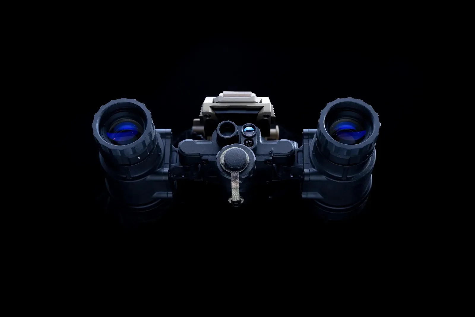 Front-facing view of binocular night vision goggles with blue lens coatings on a black background.